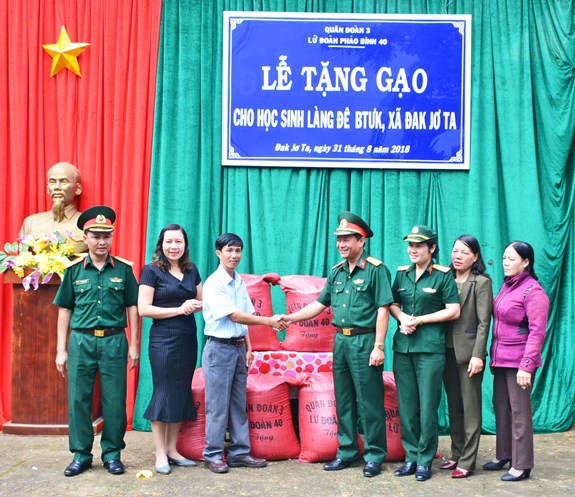 Đại diện lãnh đạo Lữ đoàn Pháo binh 40 trao gạo cho lãnh đạo Trường Tiểu học và THCS Đăk Jơ Ta.